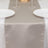 Elegant beige table runner on a dining table set with plates and glasses.