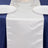 White satin table runner on a navy tablecloth with plates and glasses.