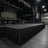 Large empty concert stage with hanging speakers and lighting rig in dark venue