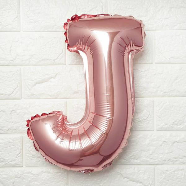 Rose gold foil letter J balloon on a white background.