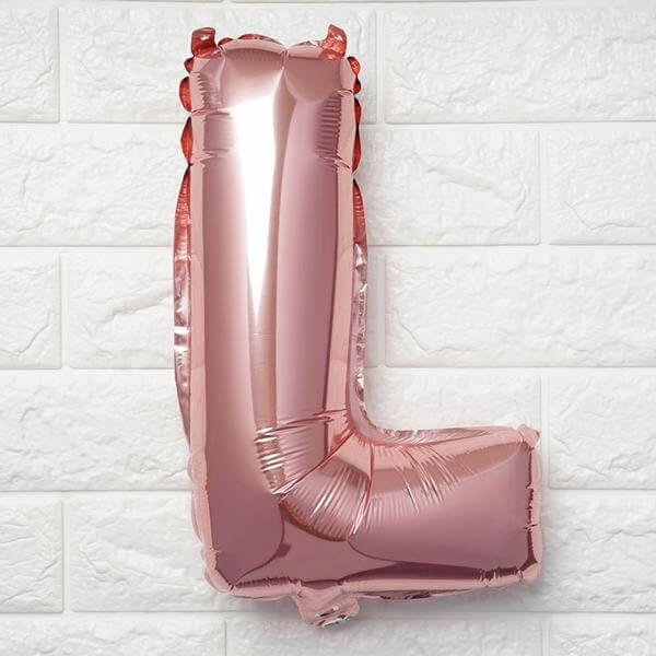 Rose gold foil balloon letter "L" on a white background.