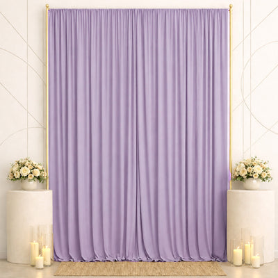 Lavender draped backdrop with floral arrangements and candles for elegant event decor