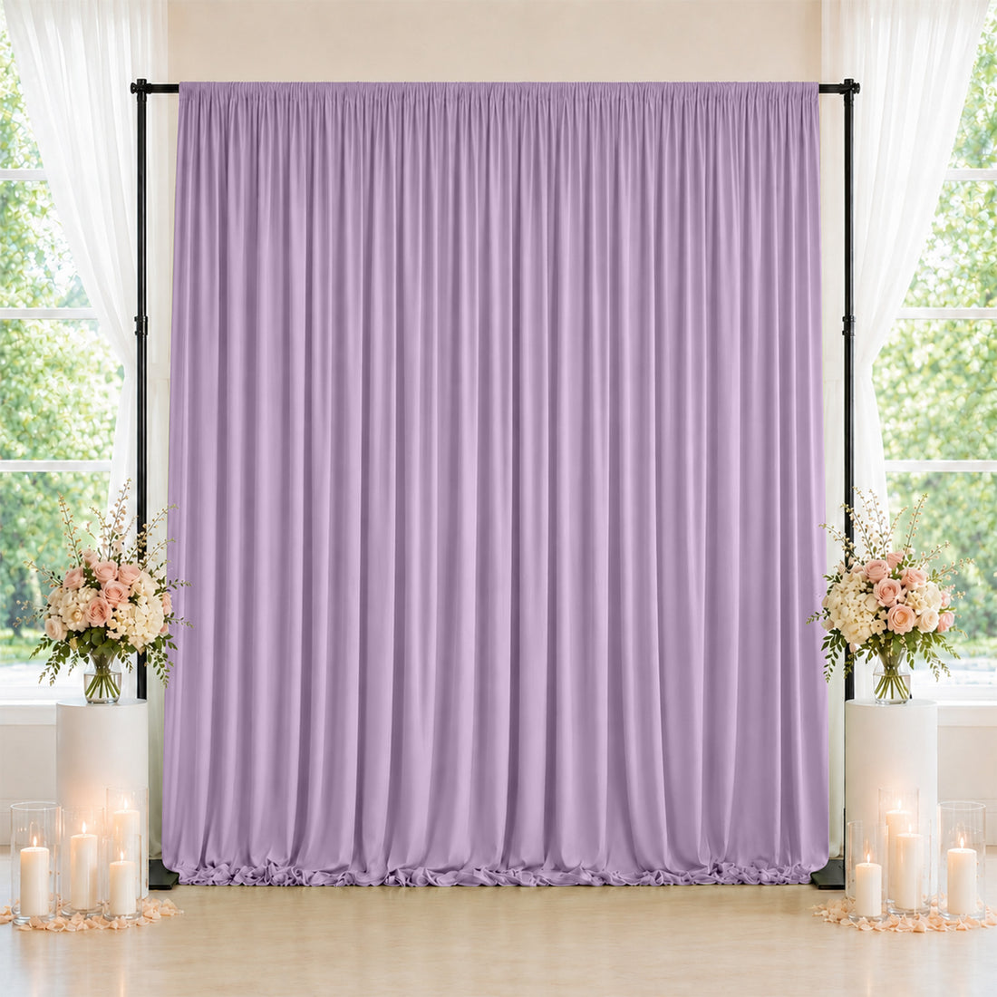 Lavender draped wedding backdrop with floral arrangements and candles