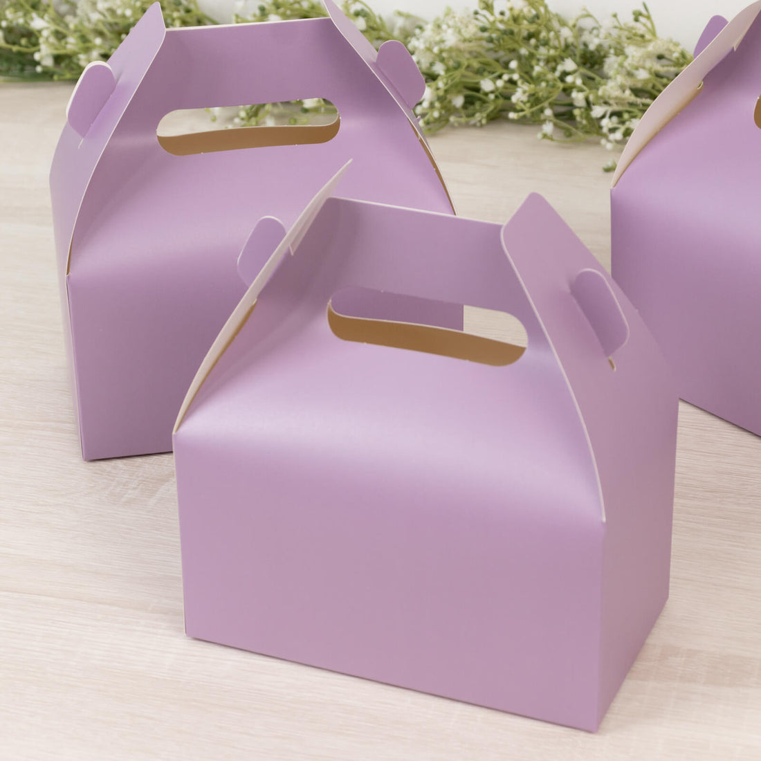 Purple takeout boxes on a wooden surface.
