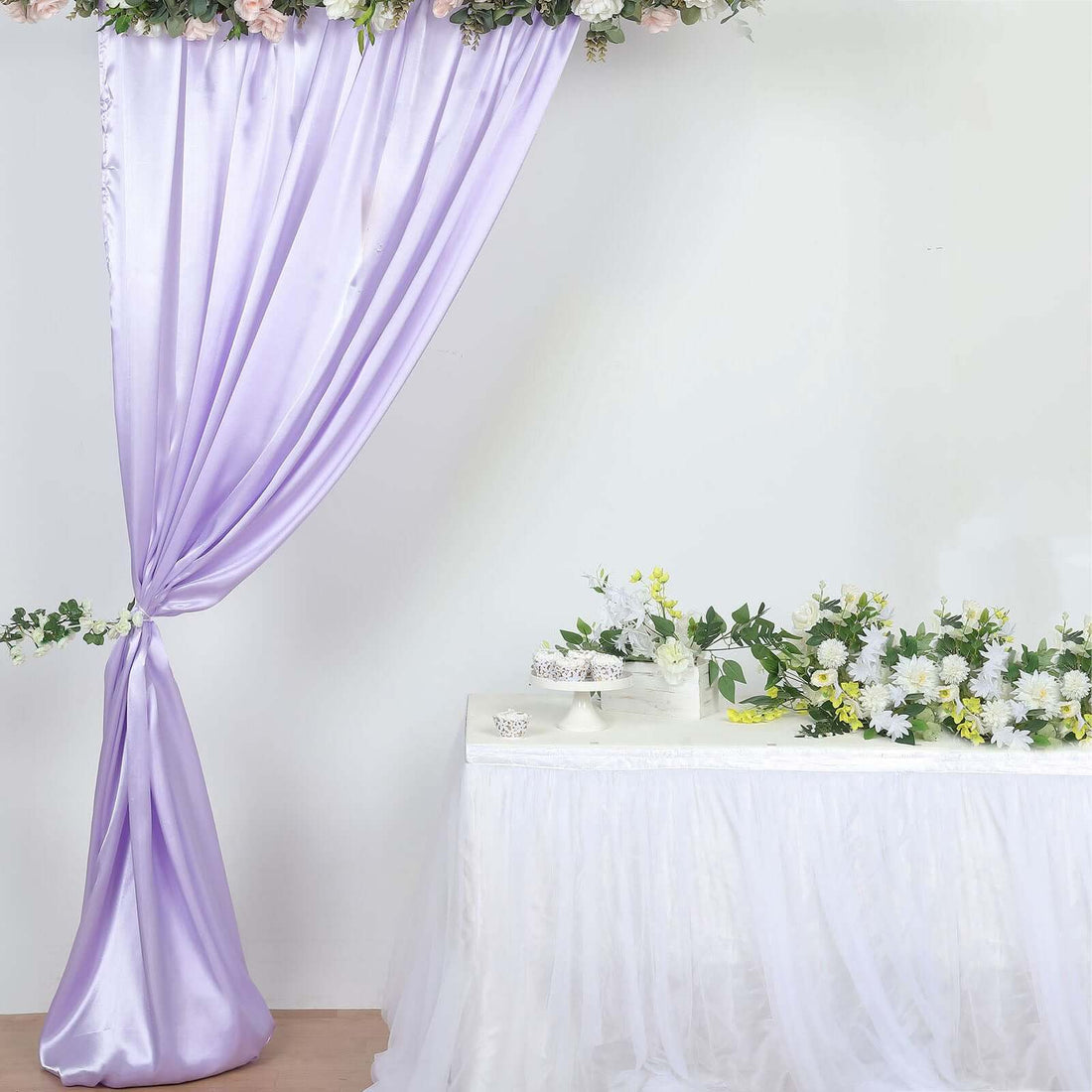 Purple drapery and floral arrangement on a table for event decoration.