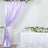 Purple drapery and floral arrangement on a table for event decoration.