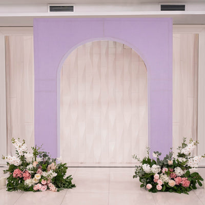 Lavender arch with floral arrangements for a wedding backdrop.