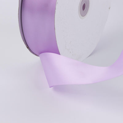 Lavender satin ribbon spool on white background