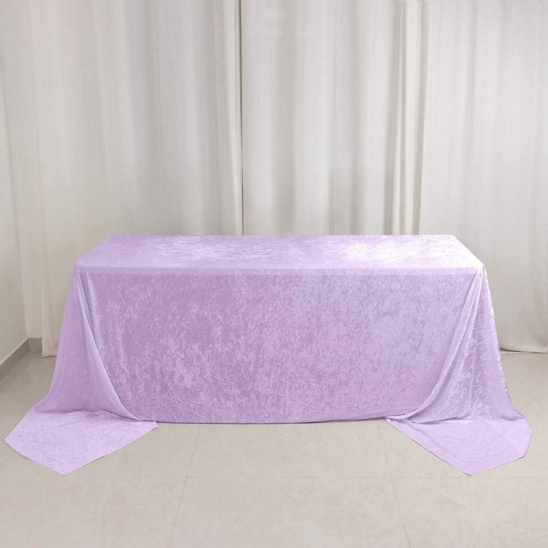 Lavender velvet tablecloth draped over banquet table against white curtains