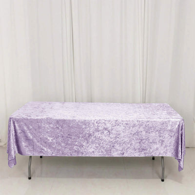 Lavender velvet tablecloth on rectangular table with white curtain backdrop