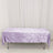 Lavender velvet tablecloth on rectangular table with white curtain backdrop