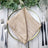Elegant beige napkin folded on a decorative plate with cutlery. #whtbkgd