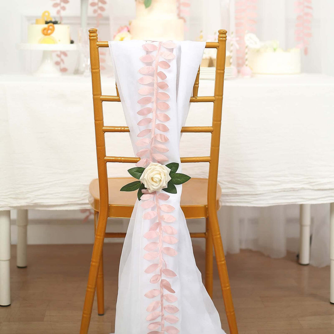 Decorative chair sash with pink petals and a rose for event styling.