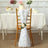 Elegant white chair sash with rose decoration for wedding decor.