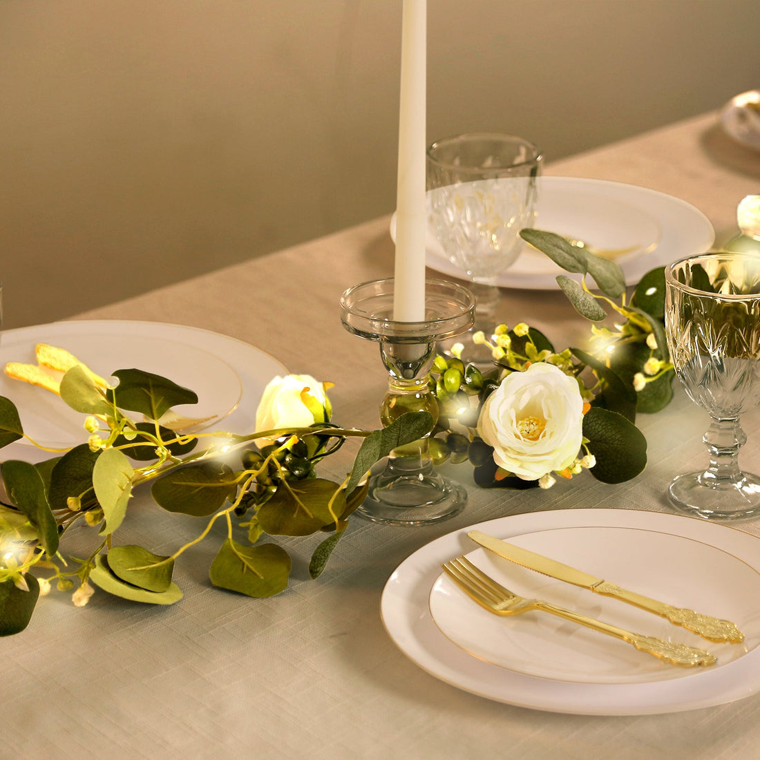 Elegant table setting with floral centerpiece, candles, and crystal glassware.