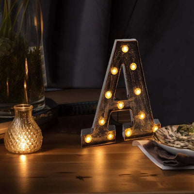 Decorative lit letter A marquee light on wooden table