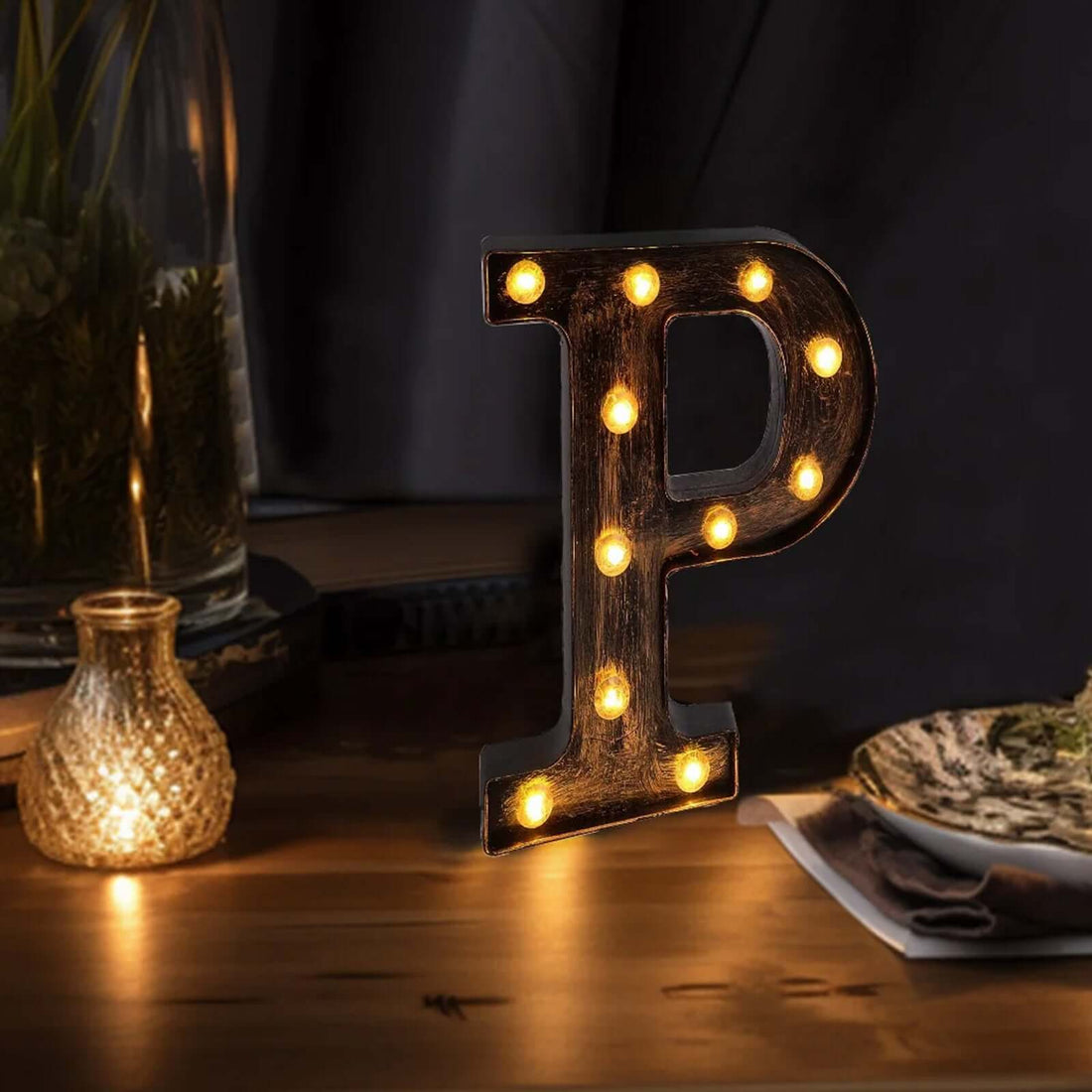 Illuminated vintage marquee letter "P" on a wooden table.