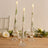 Set of three decorative candle holders with floral candles.