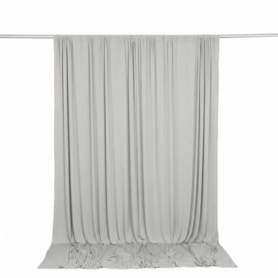 Light gray draped curtain backdrop on a rod with floor pooling fabric