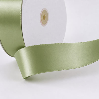 Light green satin ribbon spool close-up on white background