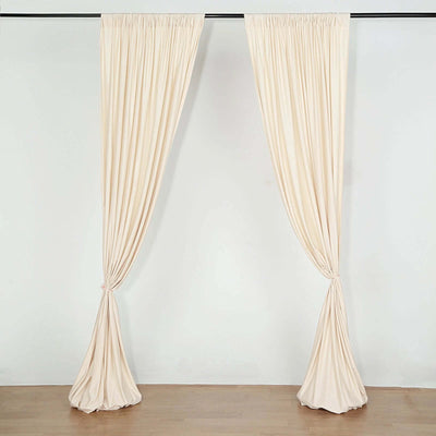 Beige curtain pair with gathered pleats, elegantly draped.