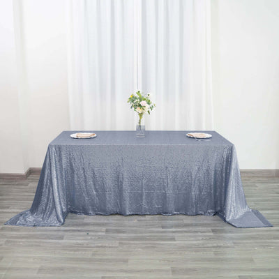 Sparkling silver tablecloth draped over a table with floral centerpiece.