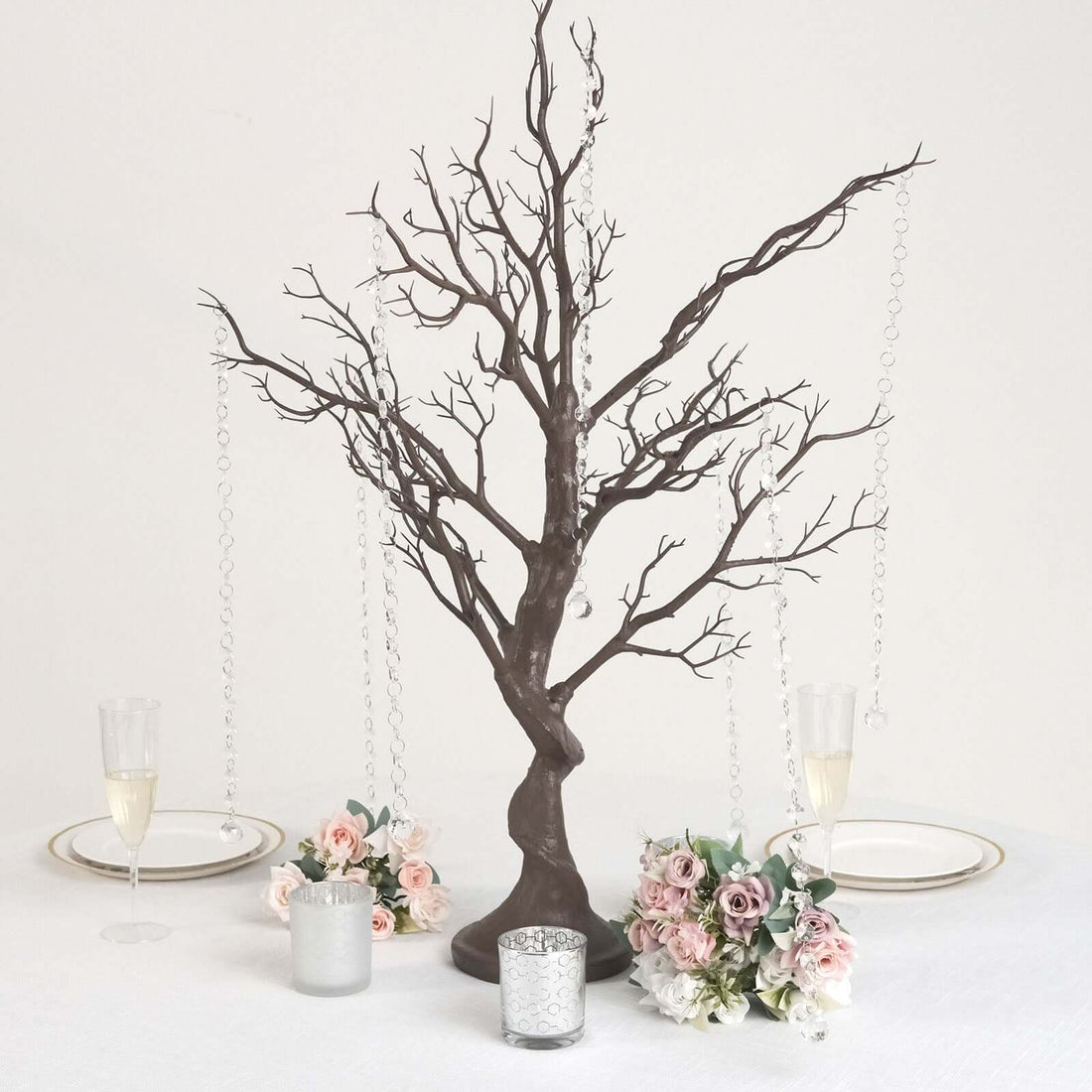Decorative black tree centerpiece with hanging crystals and floral arrangements.