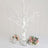 White decorative tree with crystal hangings and floral arrangements.