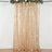 Gold sequin curtain with floral accents hanging from a rod.