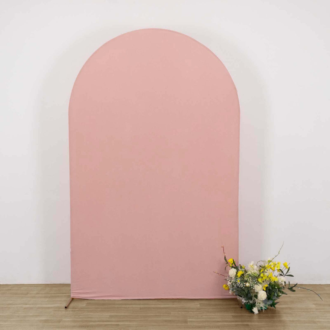 Pink arch backdrop with floral arrangement in front.