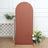 Terra cotta fabric backdrop with a curved top, decorated with flowers and greenery.