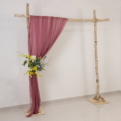 Wooden wedding arch with a burgundy drape and floral arrangement.