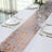 Elegant table runner with copper accents on a white table setting.