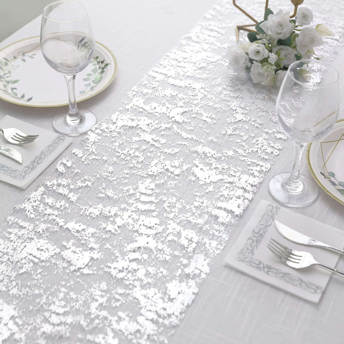 Elegant white table runner with sequins on a beautifully set dining table.