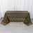 Gold and black sequined tablecloth with wavy pattern on a table.