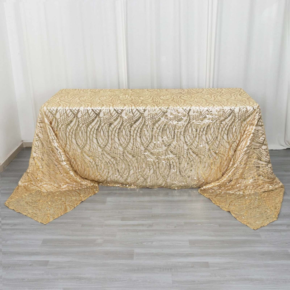 Gold sequin tablecloth with intricate pattern on a table.