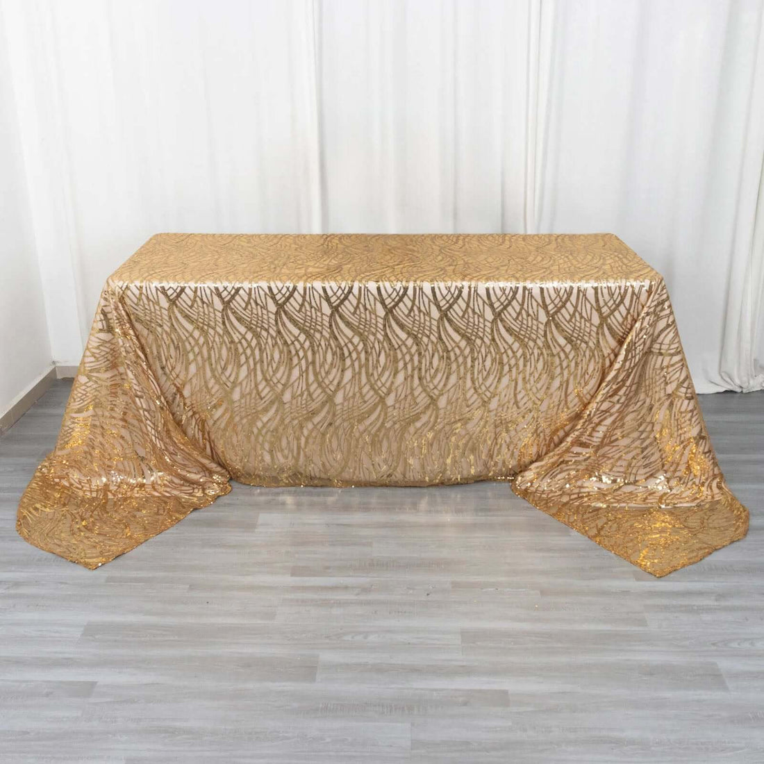 Golden tablecloth with elegant pattern draped over a table.