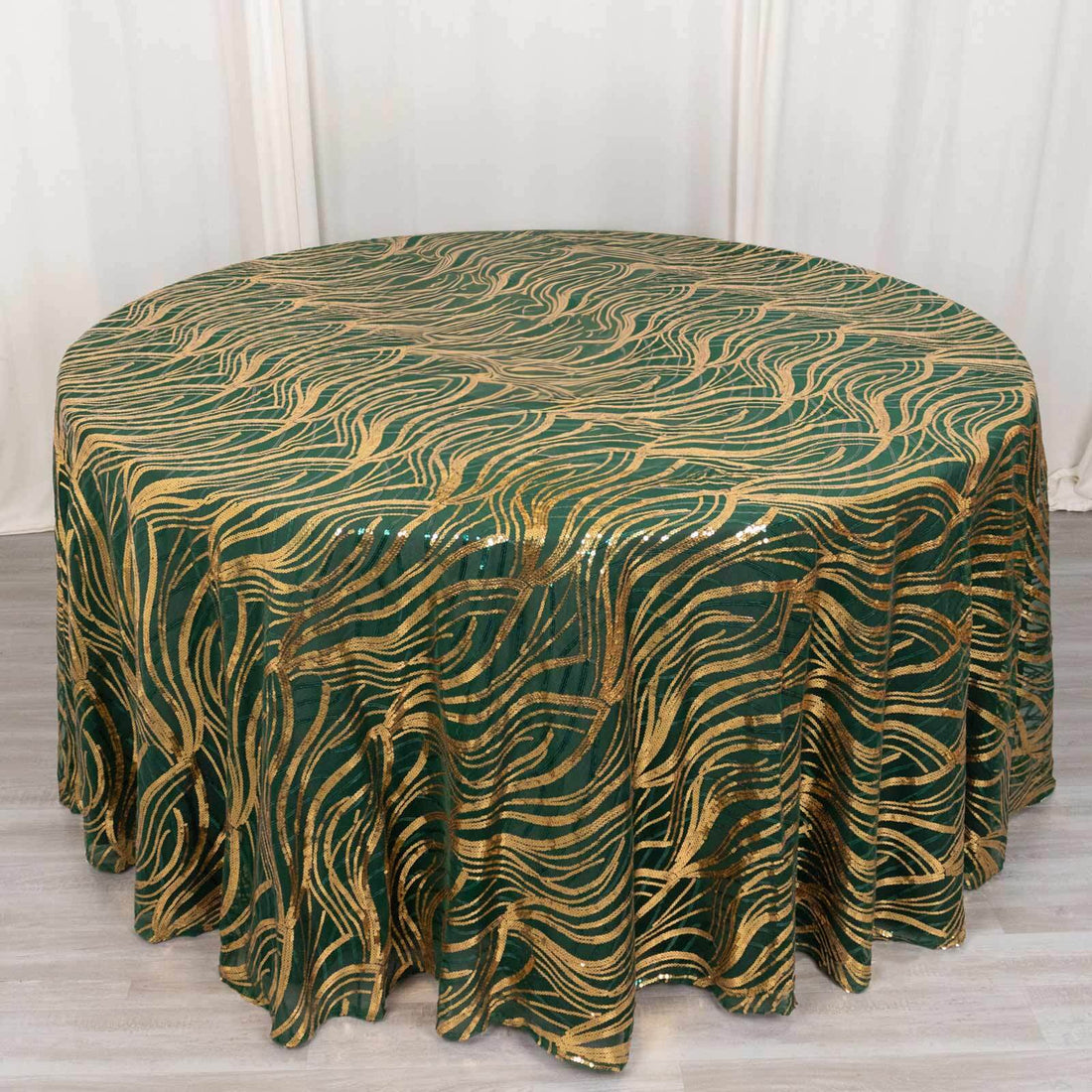 Green and gold wavy patterned tablecloth on a round table.