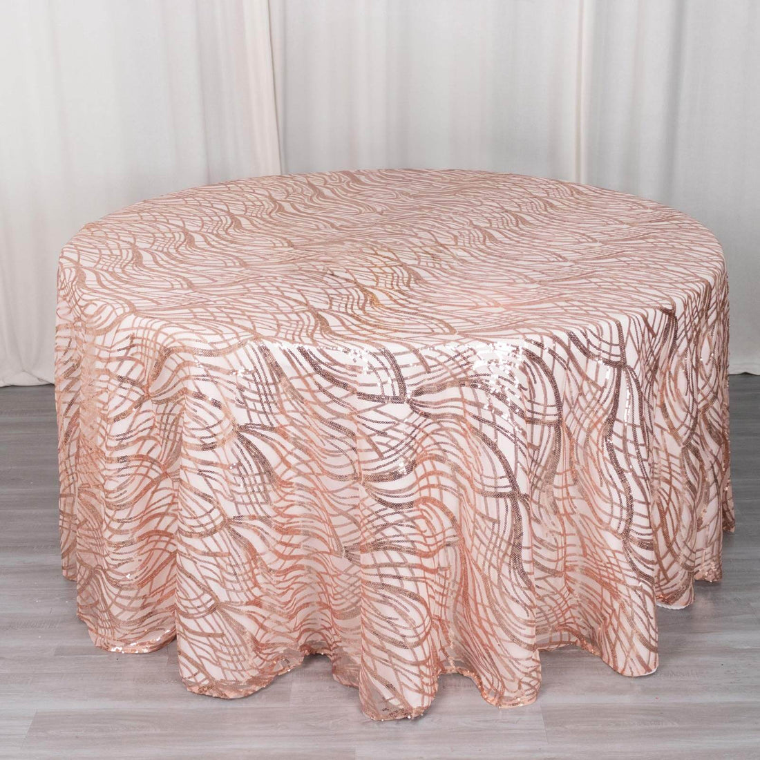 Rose gold sequined round tablecloth with wavy pattern.