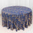 Round blue and gold patterned tablecloth on a white backdrop.
