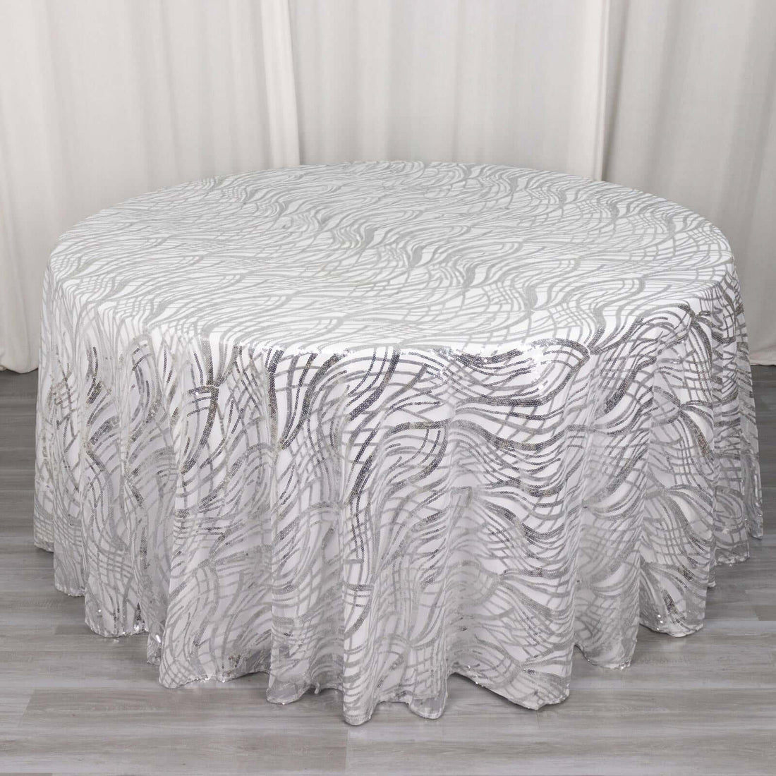 Round tablecloth with silver wave pattern on a white background.