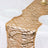 Gold sequin table runner on a dining table with plates and glassware.