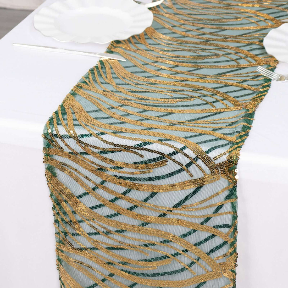 Gold and green decorative table runner on a white tablecloth.