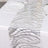 Silver wave pattern table runner on a white table.