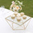 Elegant tiered dessert stand with cupcakes and floral arrangement.