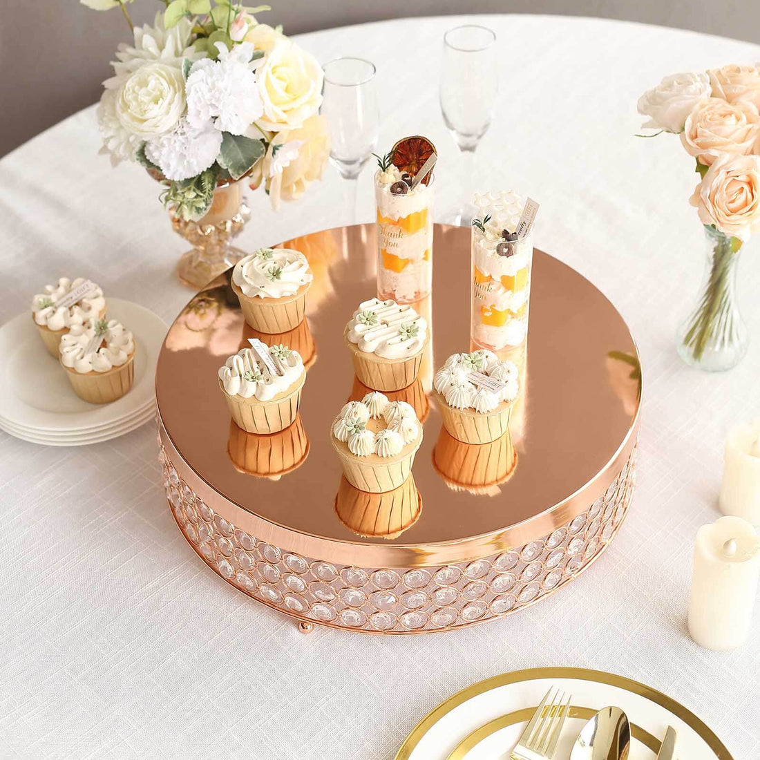 Elegant dessert display with cupcakes and parfaits on a rose gold cake stand.