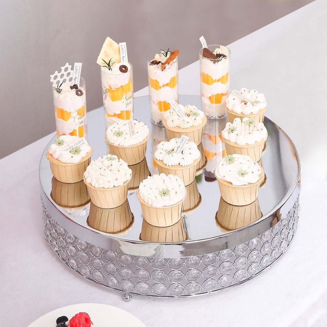 Assorted desserts displayed on a mirrored tray at an elegant event.