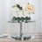 Elegant wedding cake on a crystal pedestal with floral accents.