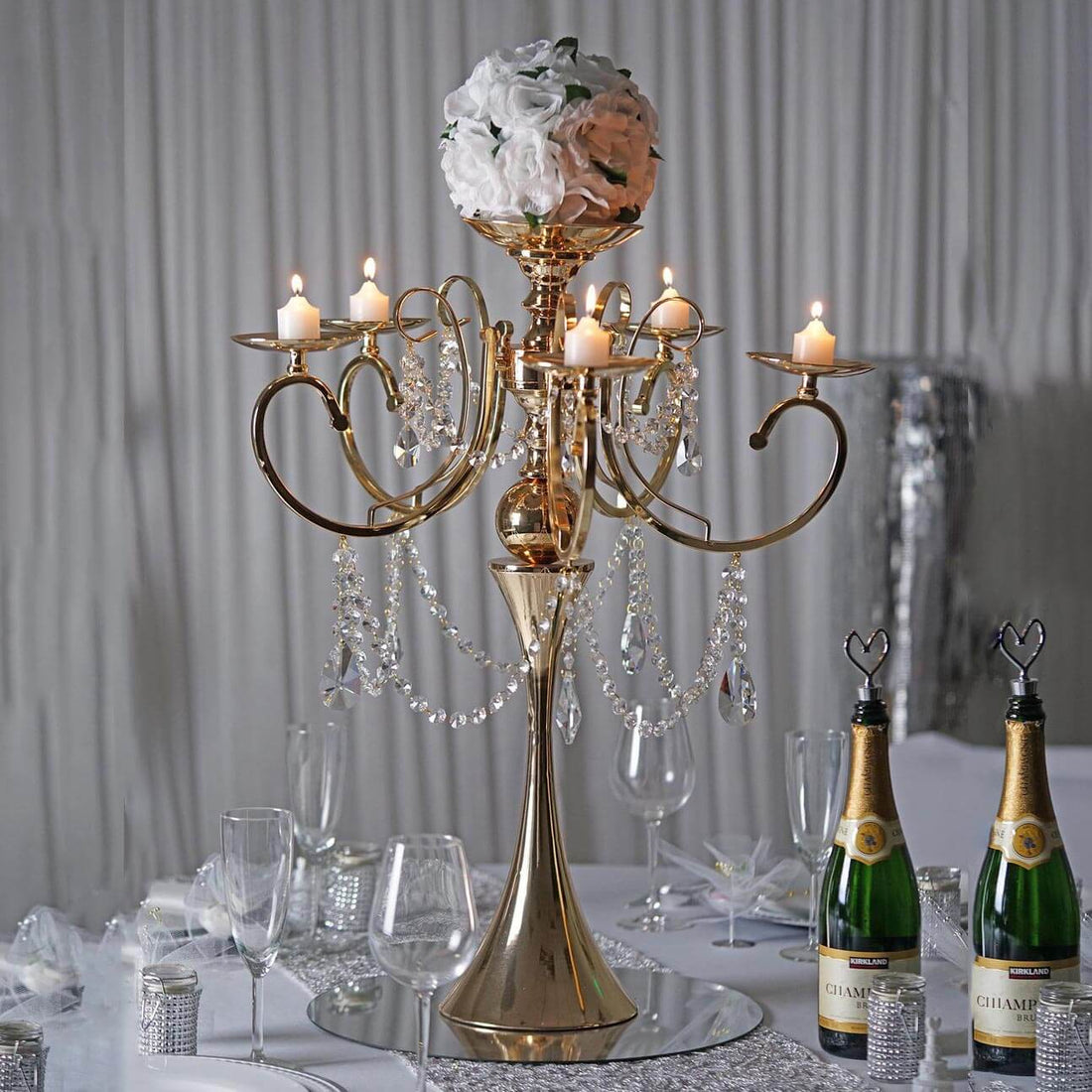 Elegant gold chandelier with floral accents and candles, perfect for events.