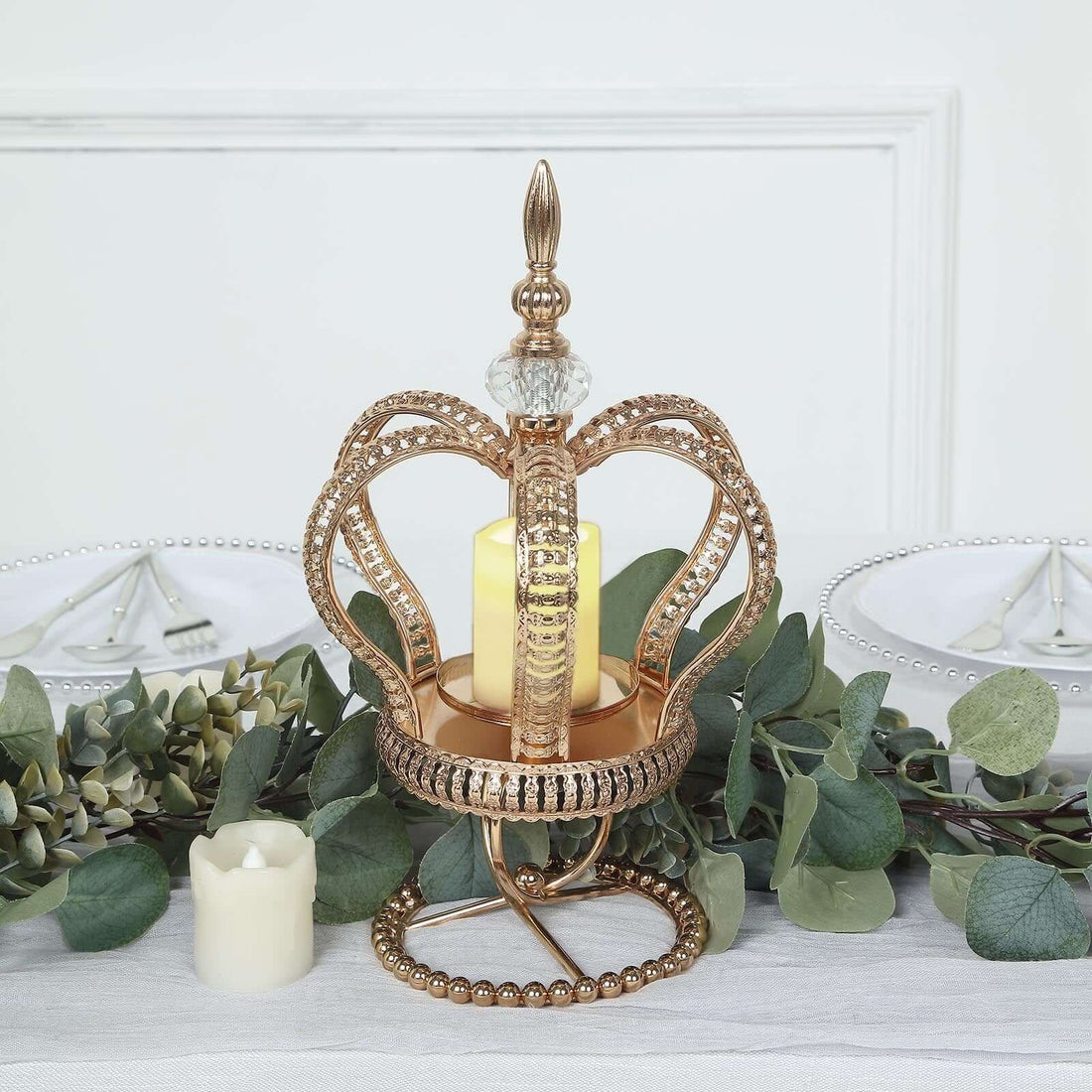 Elegant gold crown candle holder with glass accent and candles.